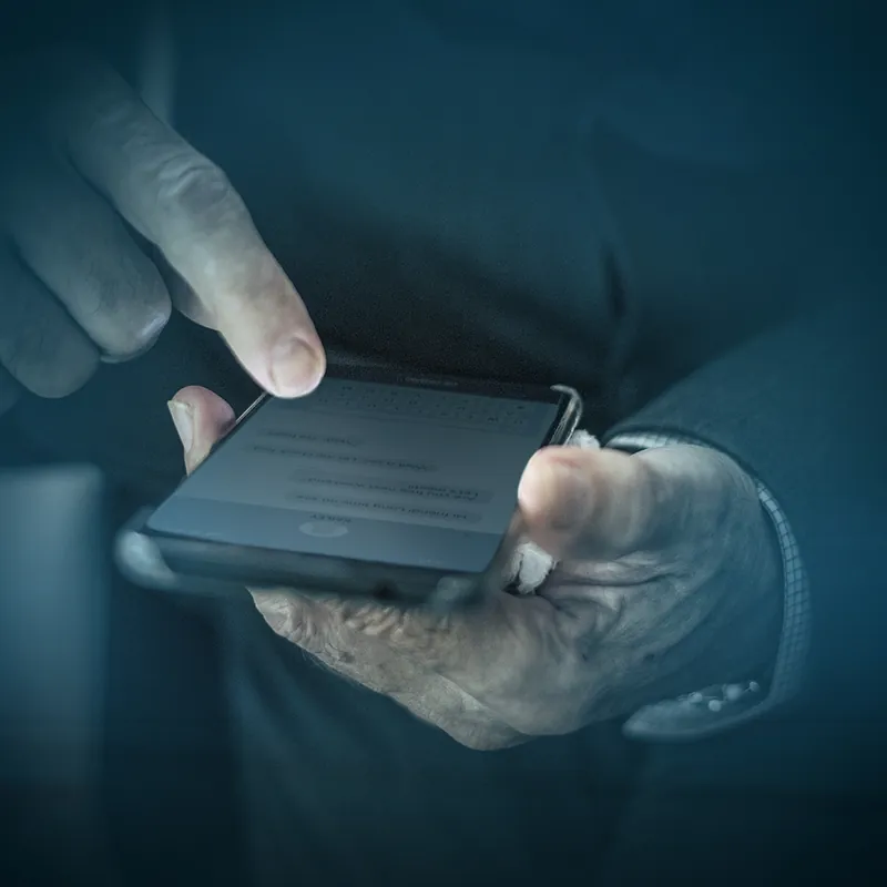 Two hands holding a phone and typing on its screen